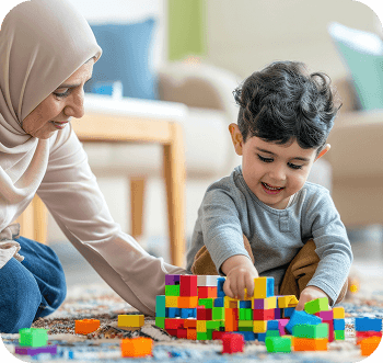 Caregiver supporting a young child during block play