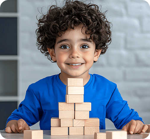 Young child smiling while stacking wooden blocks